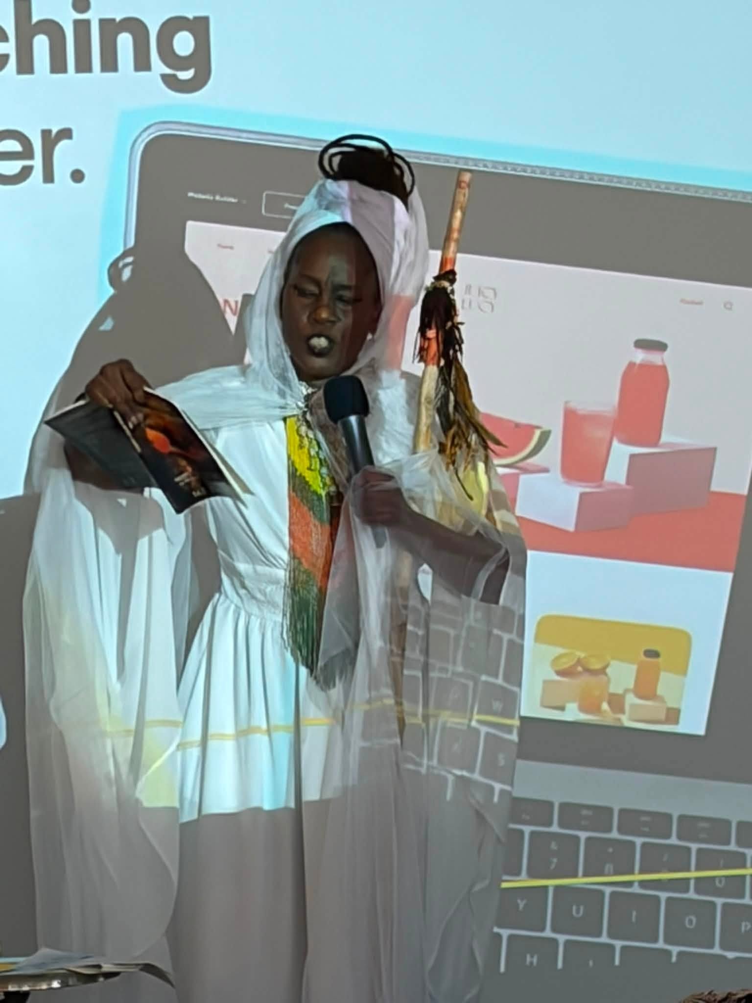 Performer in traditional attire speaking at fundraiser