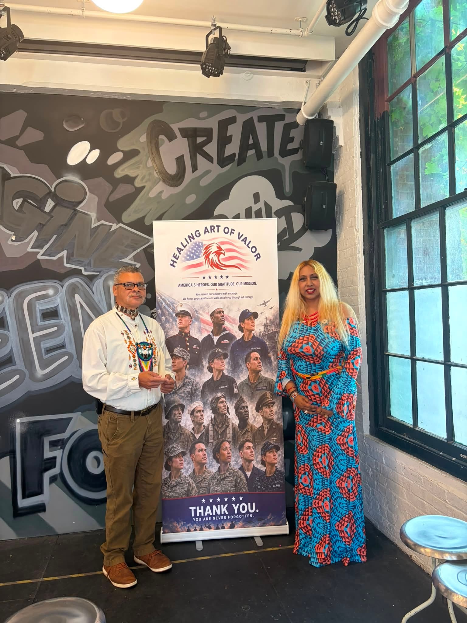Attendees with Healing Art of Valor banner at fundraiser