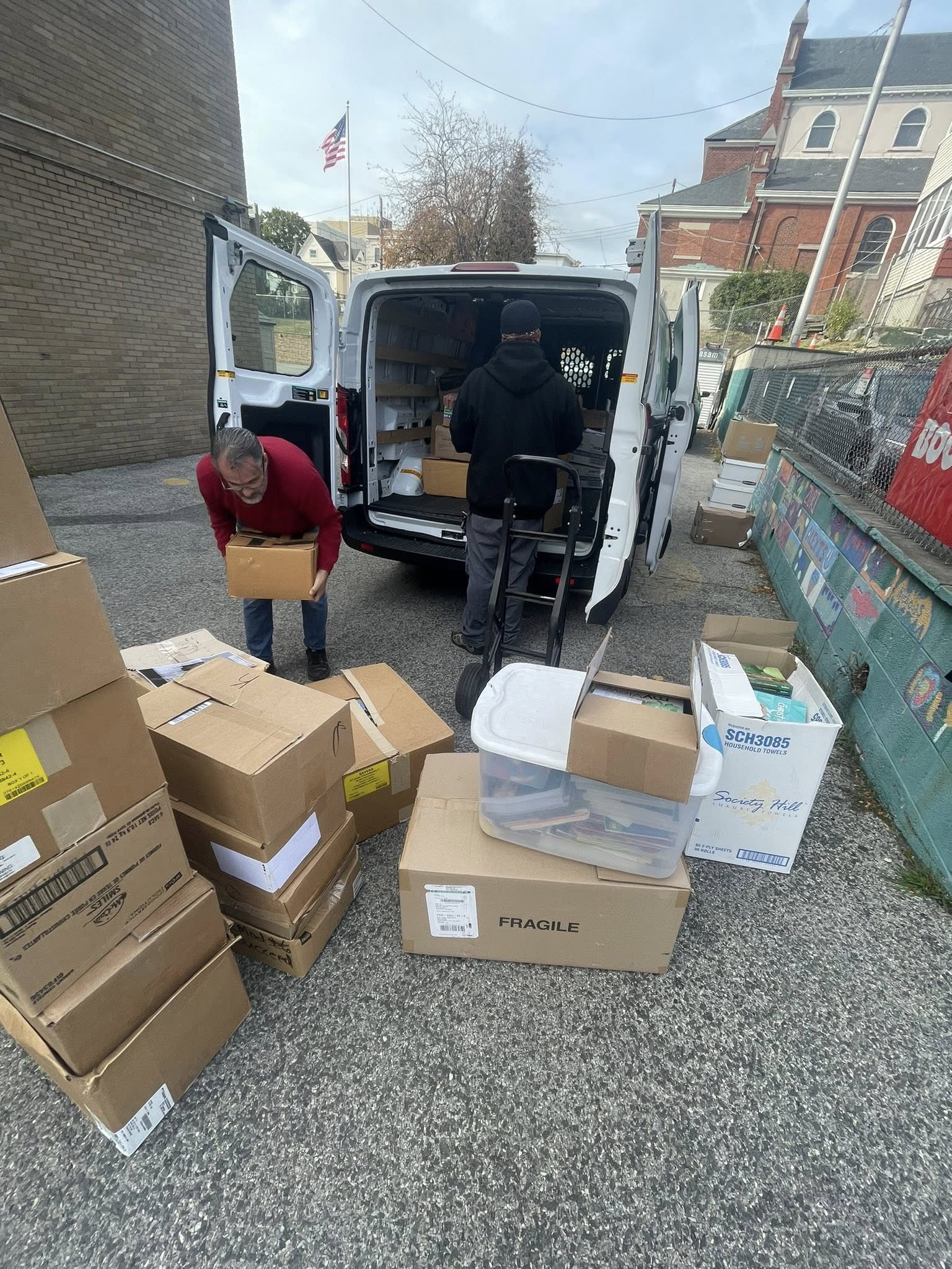 Volunteers loading donated boxes into a van for transport to storage