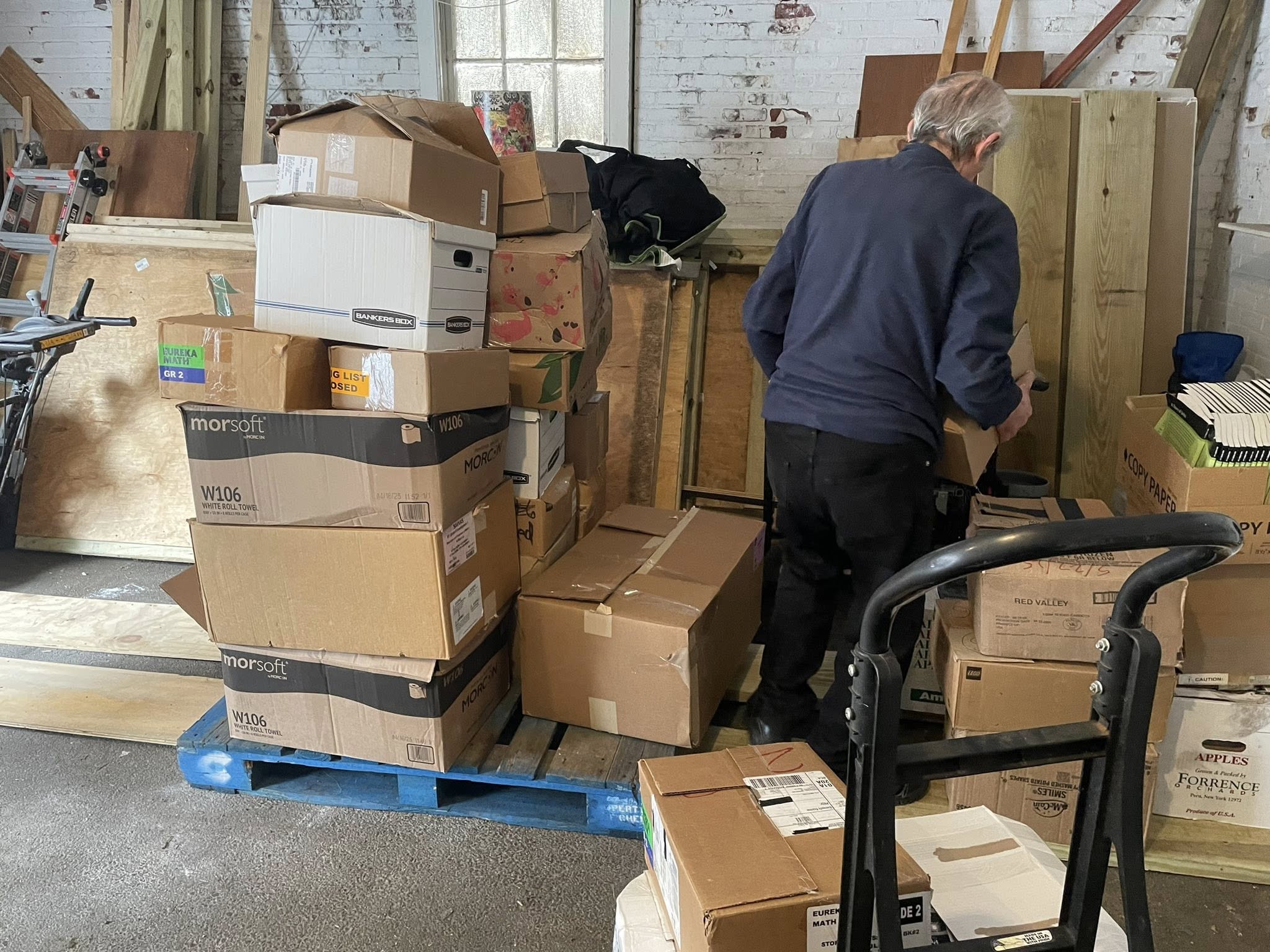 Donated educational materials stacked in storage facility