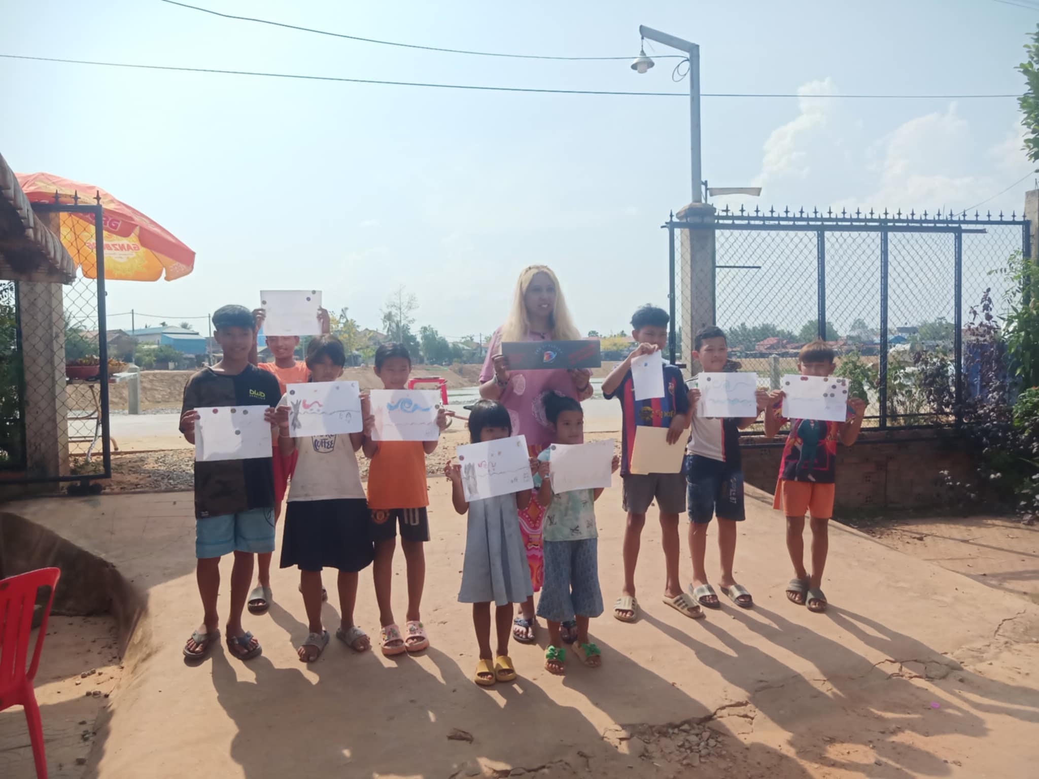 Cambodia students holding Van Gogh-inspired artwork outside